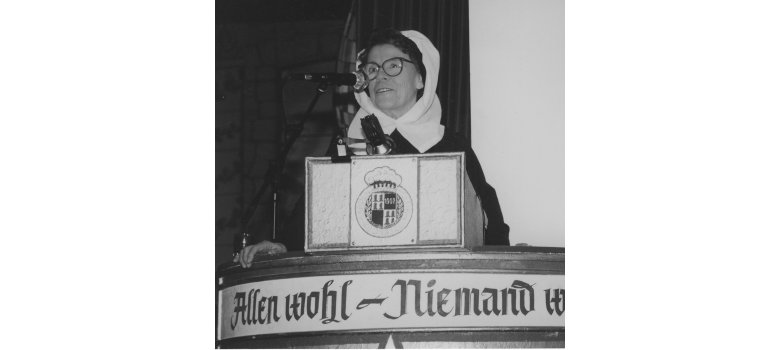 Foto von Hanna Feldmann-Bütt während sie in ein Mikrofon spricht