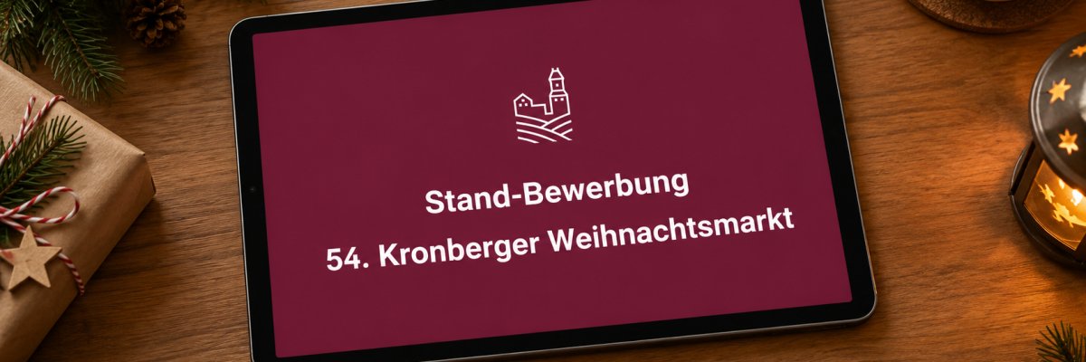Stand Bewerbung 54. Kronberger Weihnachtsmarkt Ein Tablet liegt auf einer weihnachtlich dekorierten Holzoberfläche. Auf dem Bildschirm ist ein weinroter Hintergrund mit der weißen Aufschrift „Stand-Bewerbung – 54. Kronberger Weihnachtsmarkt“ und einem stilisierten Burg-Logo zu sehen