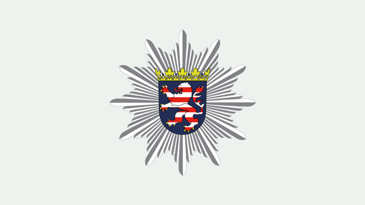 Ein silberner, vielstrahliger Polizeistern auf hellem Hintergrund. Im Zentrum des Sterns befindet sich das hessische Landeswappen: ein rot-weiß gestreifter, aufrecht stehender Löwe auf blauem Schild, der oben von einer goldenen Krone abgeschlossen wird