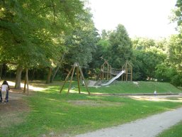 Wiese im Vordergrund und im Hintergrund eine Seilbahn sowie ein großes Klettergerüst