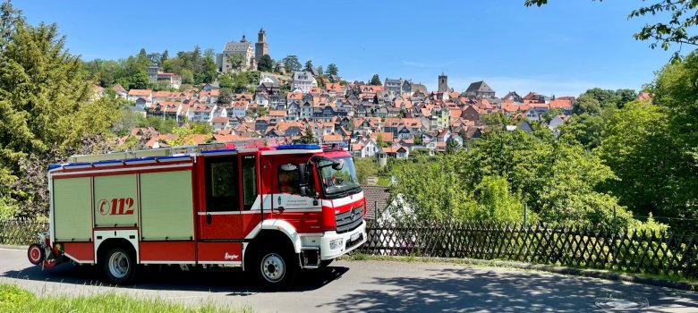 Feuerwehrfahrzeug im Vordergrund mit der Altstadt und Burg Kronberg im Hintergrund