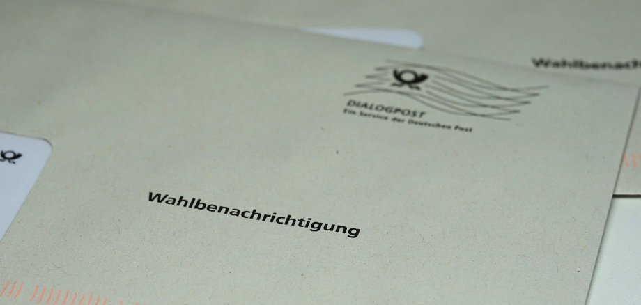 Briefwahl Ein Briefumschlag der Deutschen Post mit dem schwarzen Aufdruck „Wahlbenachrichtigung“ liegt im Fokus der Aufnahme. Im oberen rechten Bereich sind das Logo der „Dialogpost“ und ein stilisierter Poststempel zu sehen