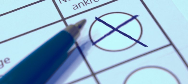 State parliament in Berlin Makroaufnahme eines offiziellen Wahlformulars; ein blauer Stift liegt daneben, nachdem ein schwarzes Kreuz in einem der runden Auswahlfelder platziert wurde. Im Hintergrund sind Textfragmente wie ‚führen‘ und ‚abhängige‘ erkennbar
