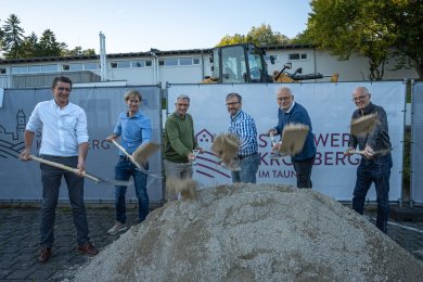 Vertreter der Stadt führen einen symbolischen Spatenstich zum Baubeginn auf einer Baustelle durch