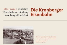 Eine beige Informationstafel mit der Überschrift „1874–2024 | 150 Jahre Eisenbahnverbindung Kronberg–Frankfurt“ auf der linken Seite und dem großen, roten Titel „Die Kronberger Eisenbahn“ rechts daneben. Im unteren Bereich befindet sich eine historische Schwarz-Weiß-Panoramaaufnahme. Rechts neben dem Foto steht ein roter Erklärungstext: „Blick über den heutigen Victoriapark auf das Bahnhofsgelände. Vor dem neuen Bahnhof steht noch das alte Stationsgebäude. Im Hintergrund ist die Pappelallee nach Oberhöchstadt zu sehen, am linken Bildrand die Villa de Ridder. Foto: Adolf Neubronner, vor 1935. Stadtarchiv Kronberg, AN_16“