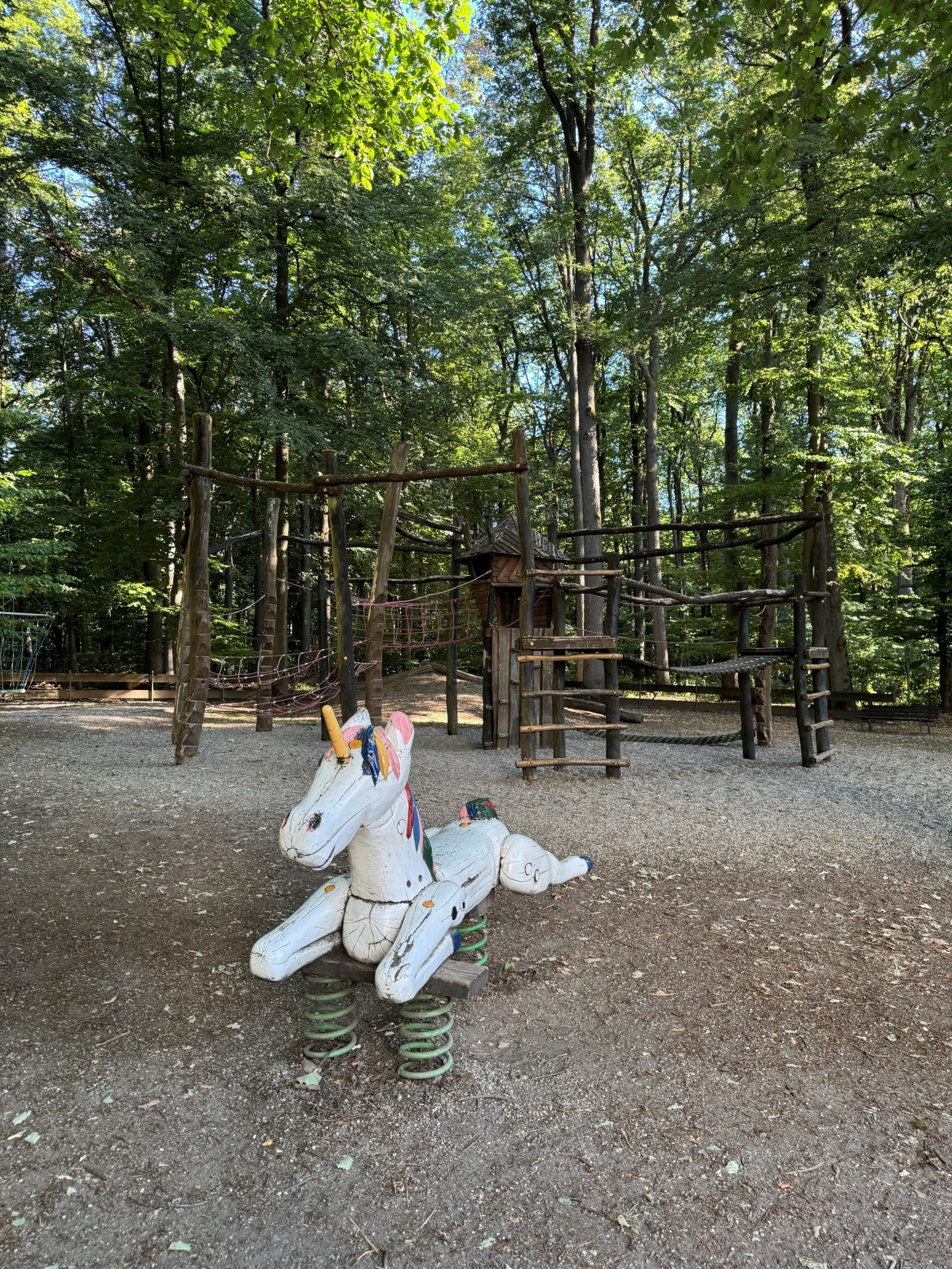 Spielplatz am weißen Berg mit einem Holzeinhorn im Fokus