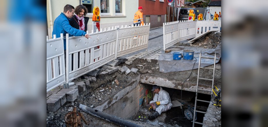 Sandra Poschmann und Christopher Wiegand vom Fachbereich Stadtentwicklung und Umwelt machen sich ein Bild vom Fortgang der Kanalsanierung in der Limburger Straße.